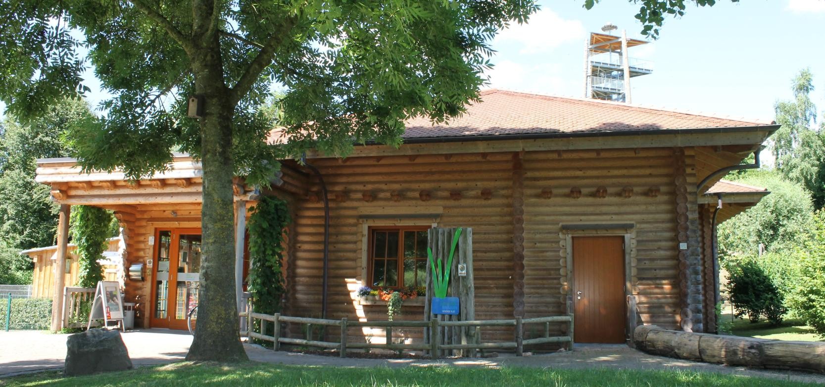 Frontansicht des Naturzentrums mit Aussichtsturm im Hintergrund