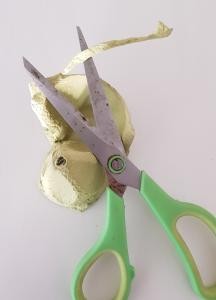 Überflüssiges wegschneiden Eine Schere schneidet Überflüssiges an der Eierbecher-Kammer ab